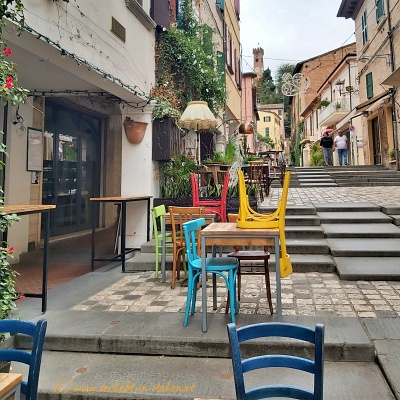 Bunte Stühle im Gastgarten